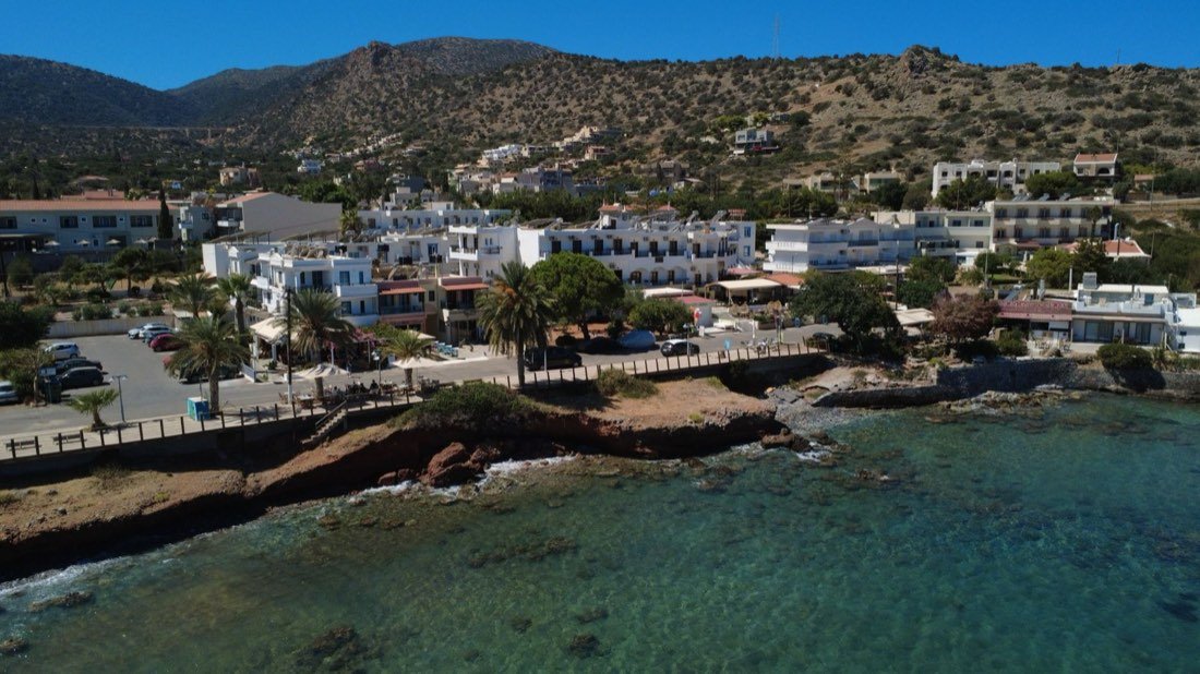 Pueblo costero de casas blancas junto a un mar turquesa.